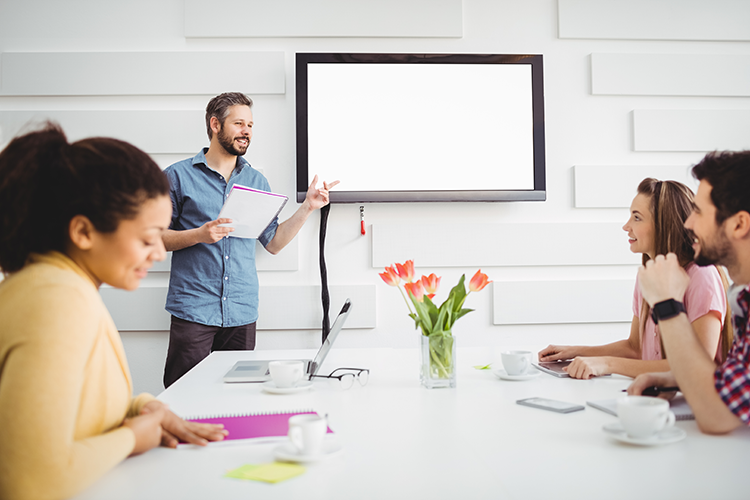 happy-executive-giving-presentation-colleagues-meeting-room-creative-office